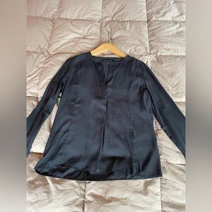 Silky black shirt with slit at neck. One button at the wrist.